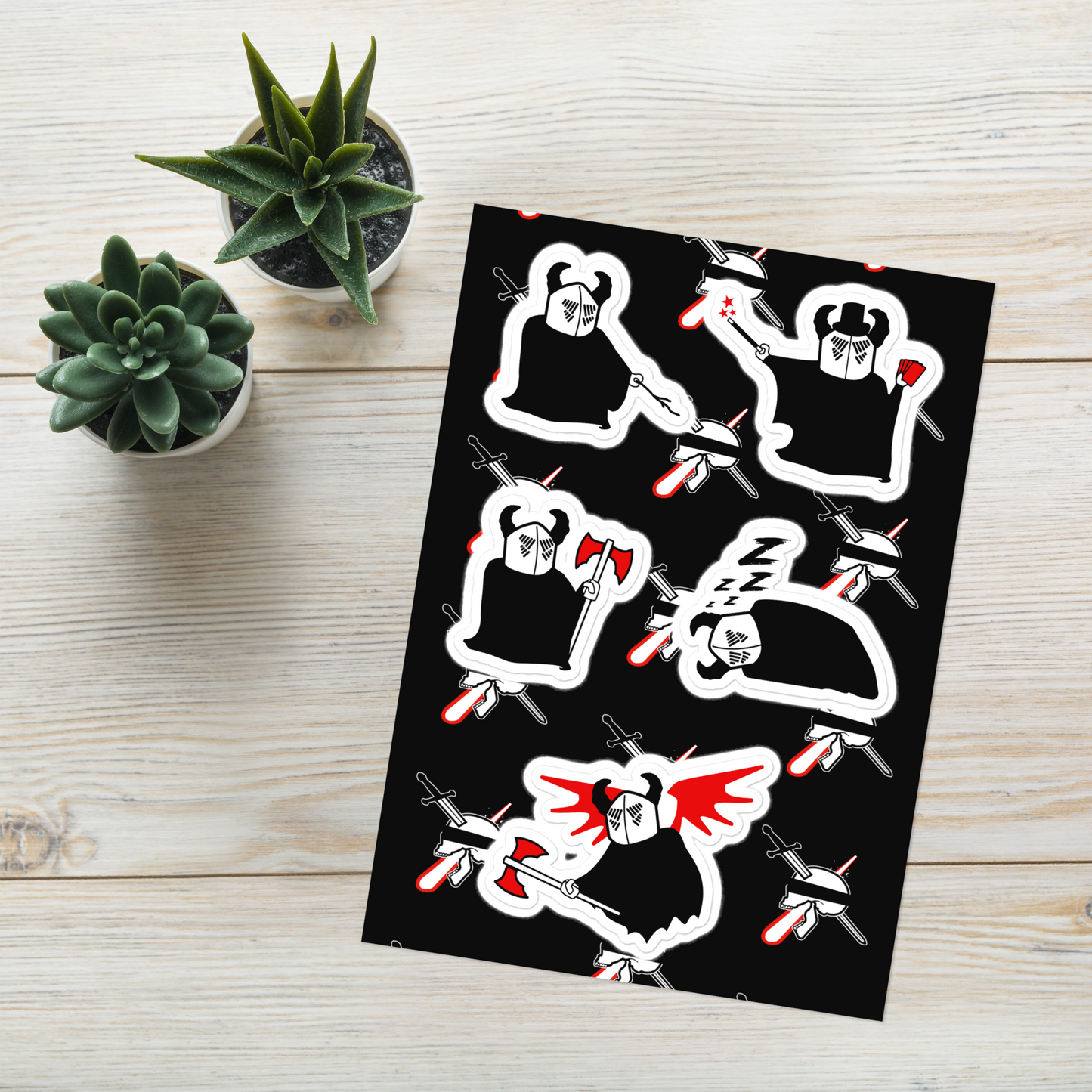 Sheet of stickers with neorebellion mascot character Oz illustrations on a black background, placed on a wooden surface with small plants.
