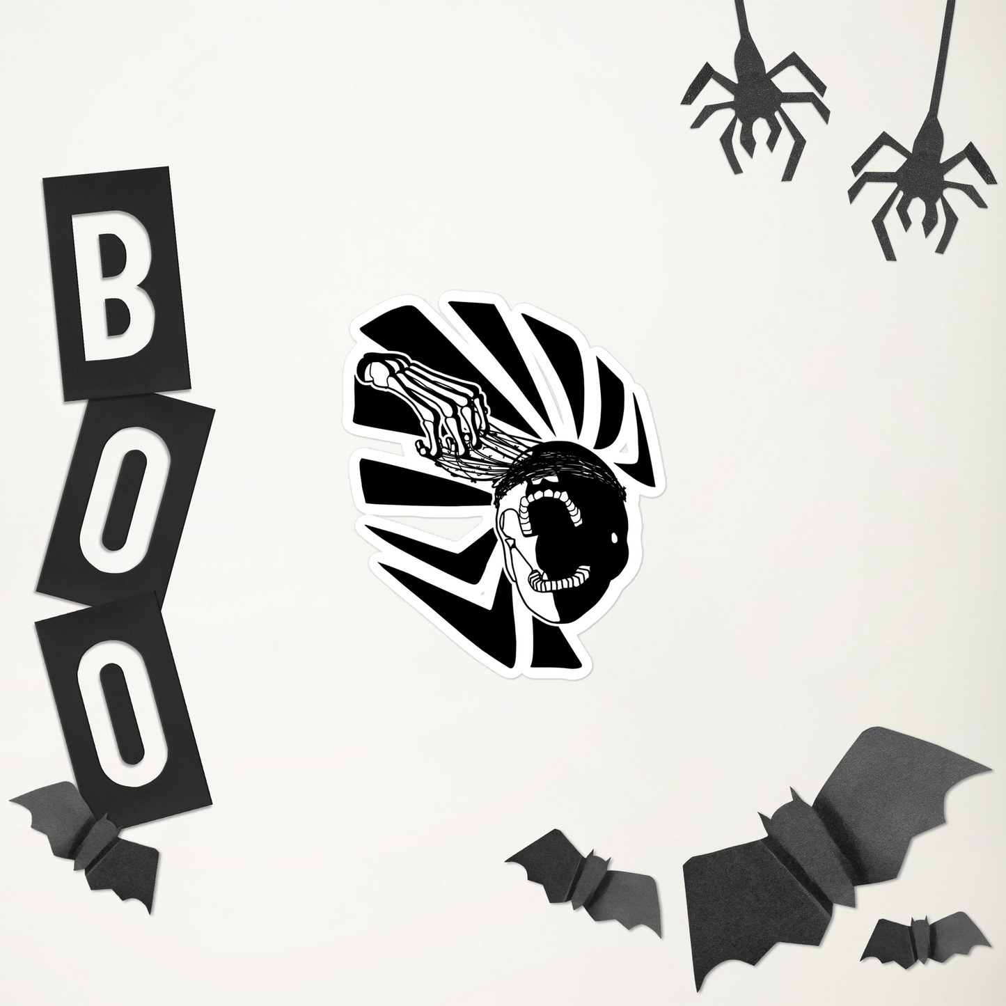 Halloween-themed decorations including a black and white striped candy corn, 'BOO' letters, bats, and spiders on a white background.