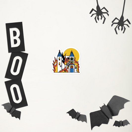 A sticker of a silly sticker with a colorful illustration of a giant monster attacking a flaming church full of teddy bears in front of Halloween-themed decorations including 'BOO' letters, a castle illustration, and bats on a white background.