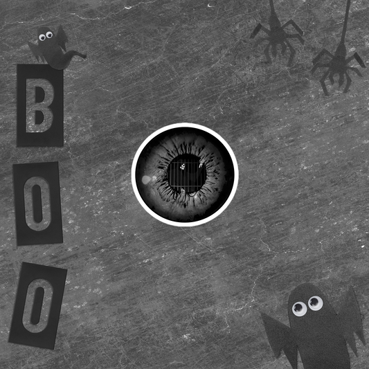 Black and white sticker of an eye with a caged grim reaper in the iris in front of Halloween-themed 'BOO' text, and spider silhouettes on textured background.