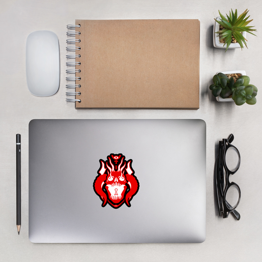 Laptop with a red and black design on a desk with a notebook, mouse, and plants.