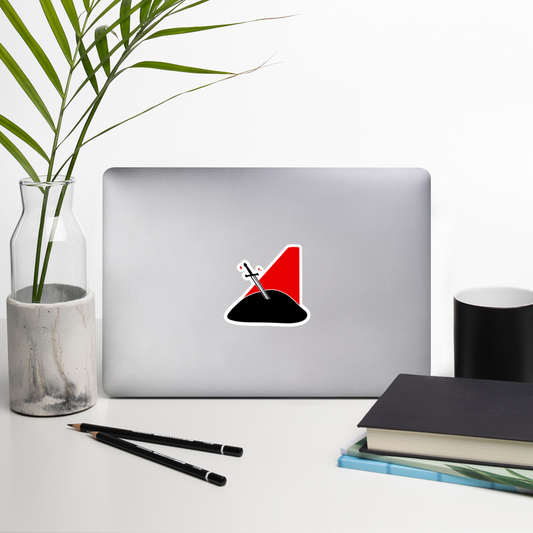 Laptop with a unique design on a desk with a plant, books, and a mug.