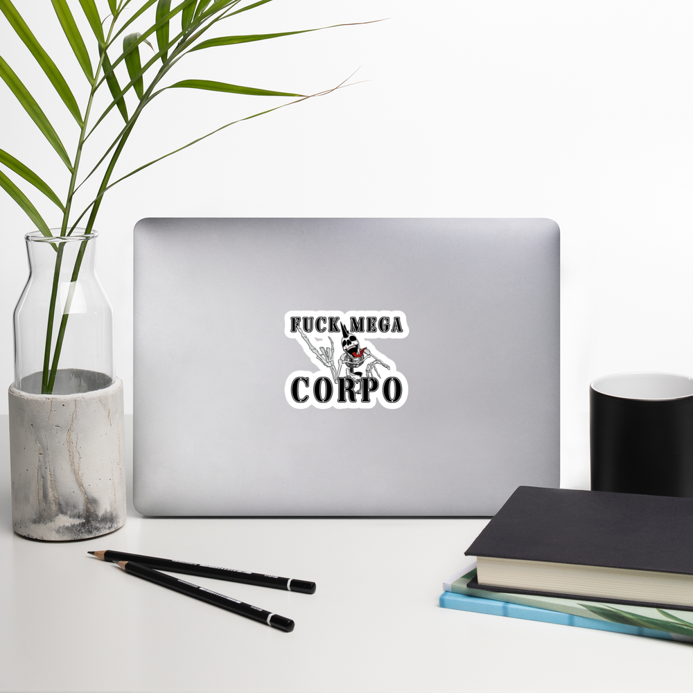 Laptop with a sticker with the text 'FUCK MEGA CORPO' and a graphic of a chrome skeleton with a mohawk on a desk with a plant, pencils, and books.
