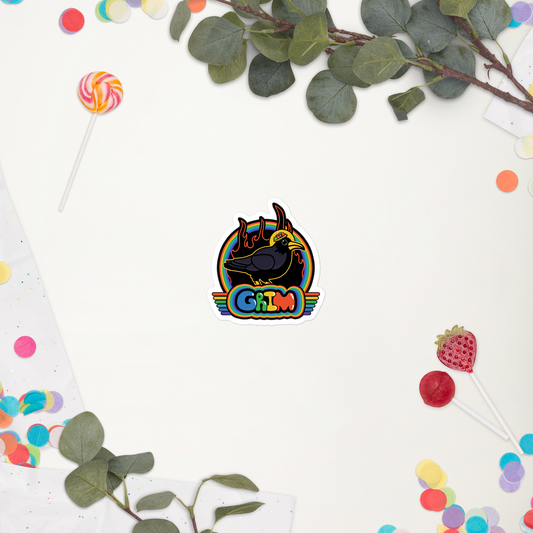 Colorful sticker with a black bird design on a white background with green leaves and colorful candies.