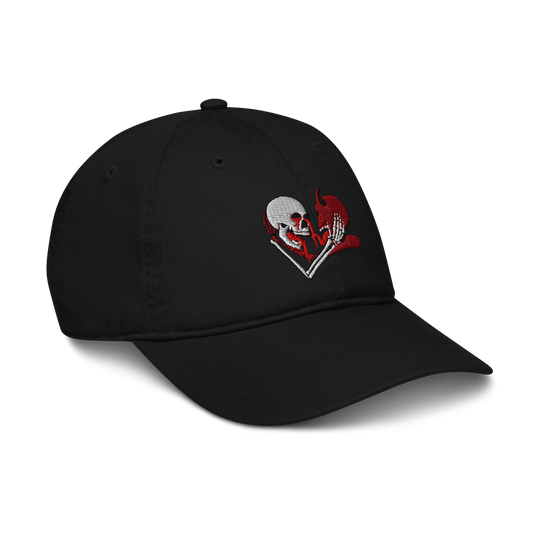 a black hat with an embroidered skeleton and demon embracing each other with white, red, and black colors