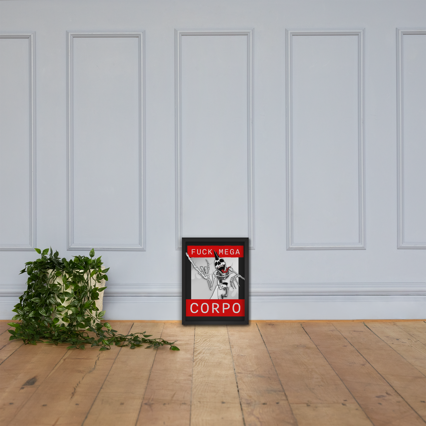 Framed artwork of a heavy metal skeleton in front of 'FUCK MEGA CORPO' text with red, white, black, and grey coloration on a white wall with wooden floor next to a plant