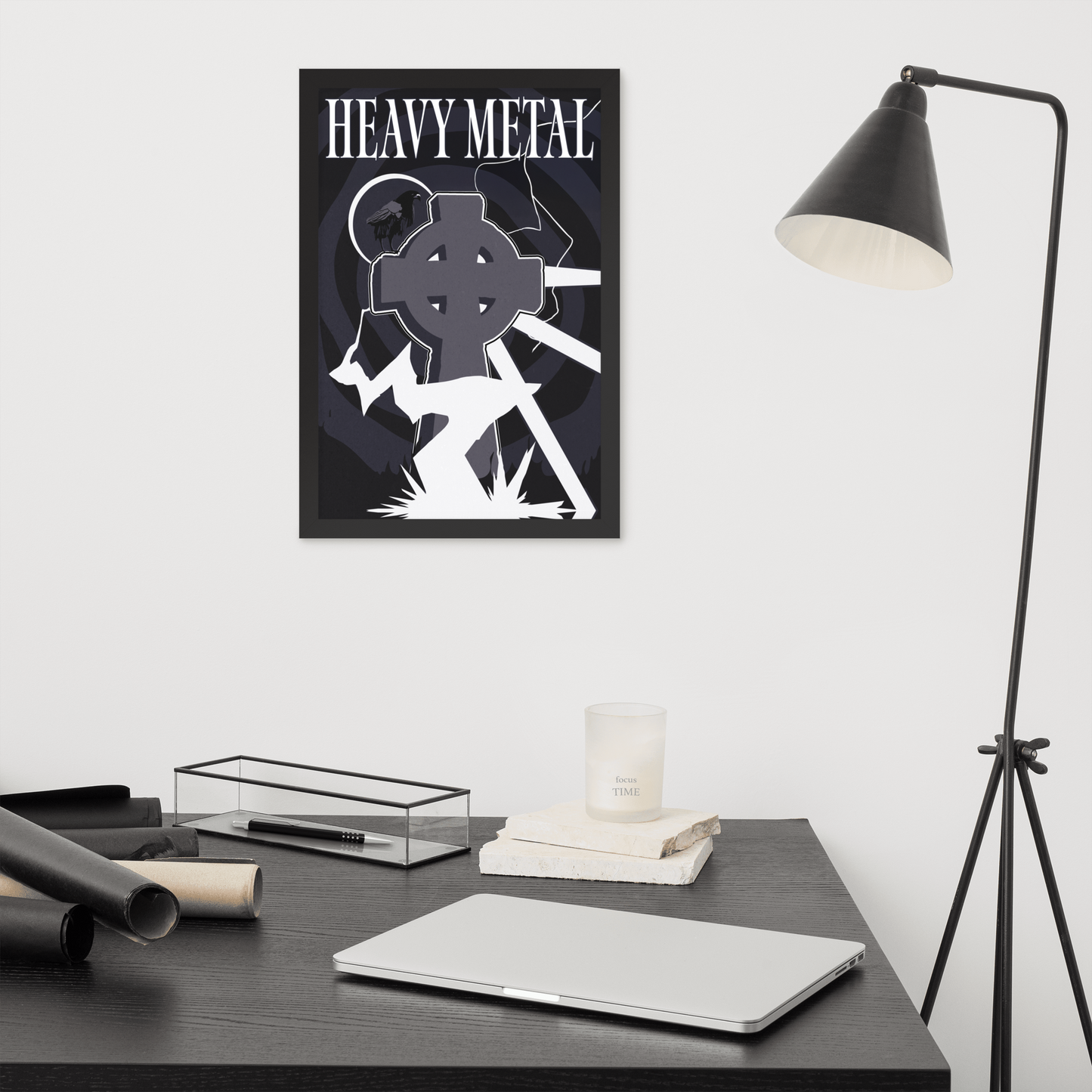 Framed 'Heavy Metal' poster on a wall above a desk with a laptop and decor items.