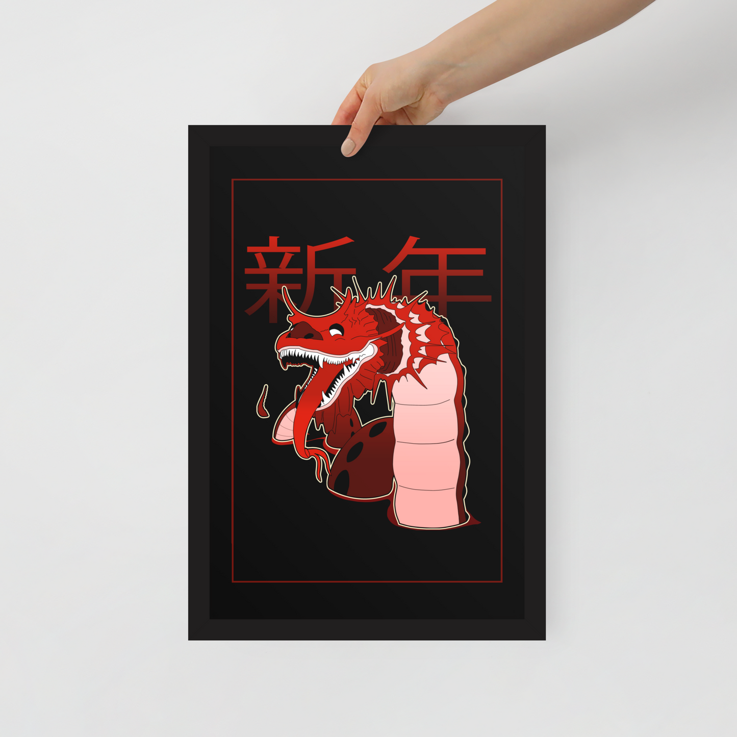Framed artwork with a red dragon design and Chinese characters on a white background being held in front of a white wall