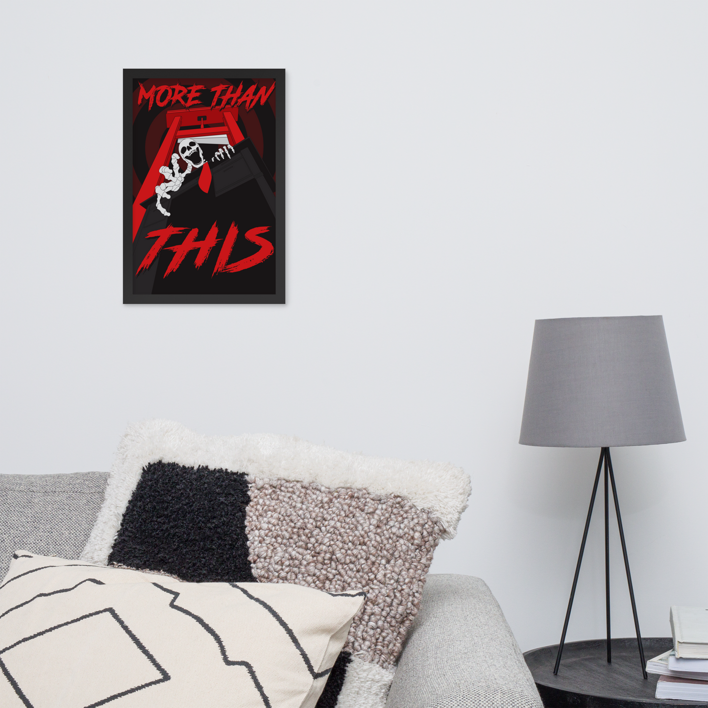 Poster with 'More Than This' text on a wall above a sofa with decorative pillows and a lamp.