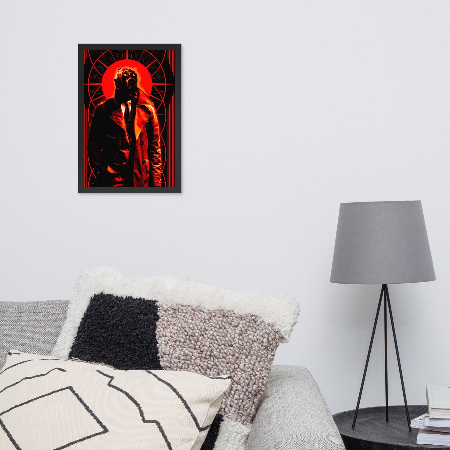 12x18 framed artwork of a stylized, art-deco style illustration in orange, black, and white tones, with a mysterious figure in a gas mask and a trench coat in the center on a wall above a sofa with decorative pillows and a lamp.