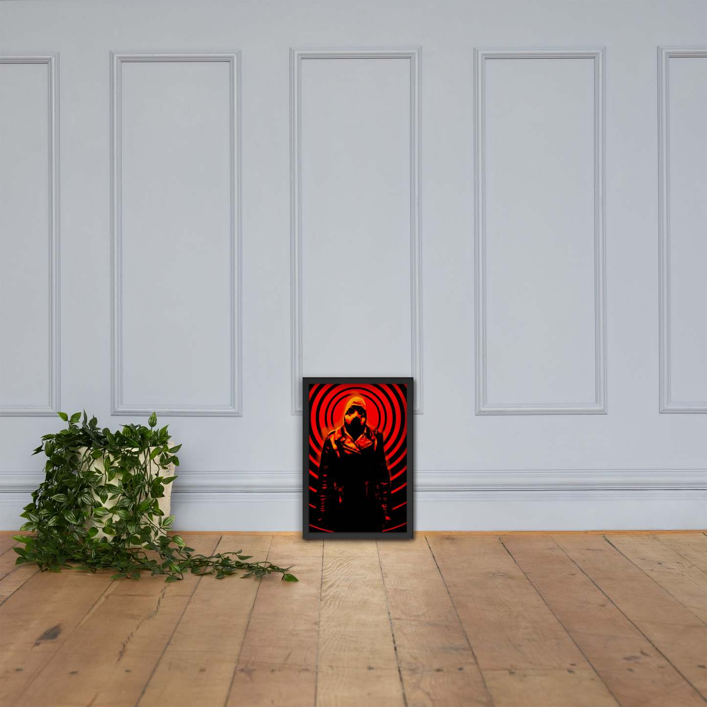 12x18 framed artwork with a orange and black mysterious figure in a dark outfit with a hood and a gas mask against an design on a white paneled wall.