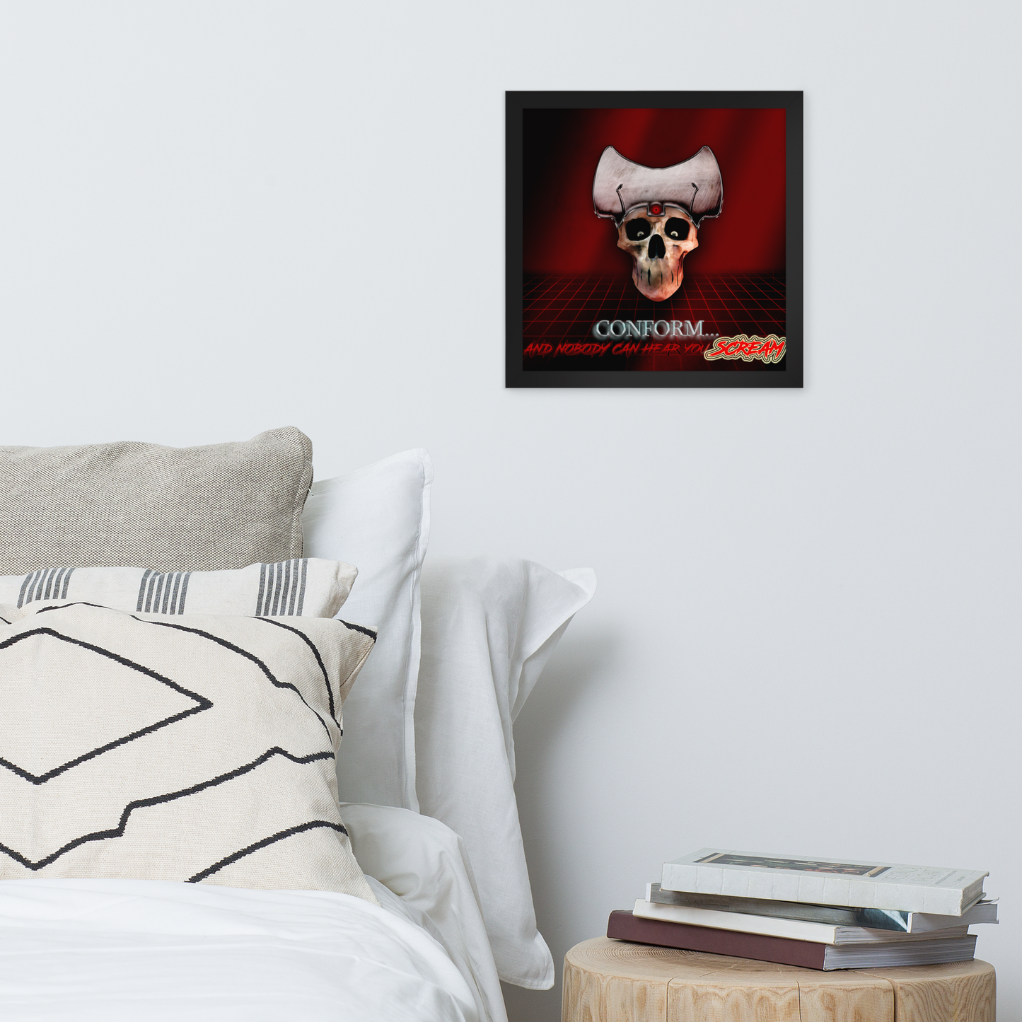 Framed poster with a skull design above a bed with pillows and books on a nightstand.