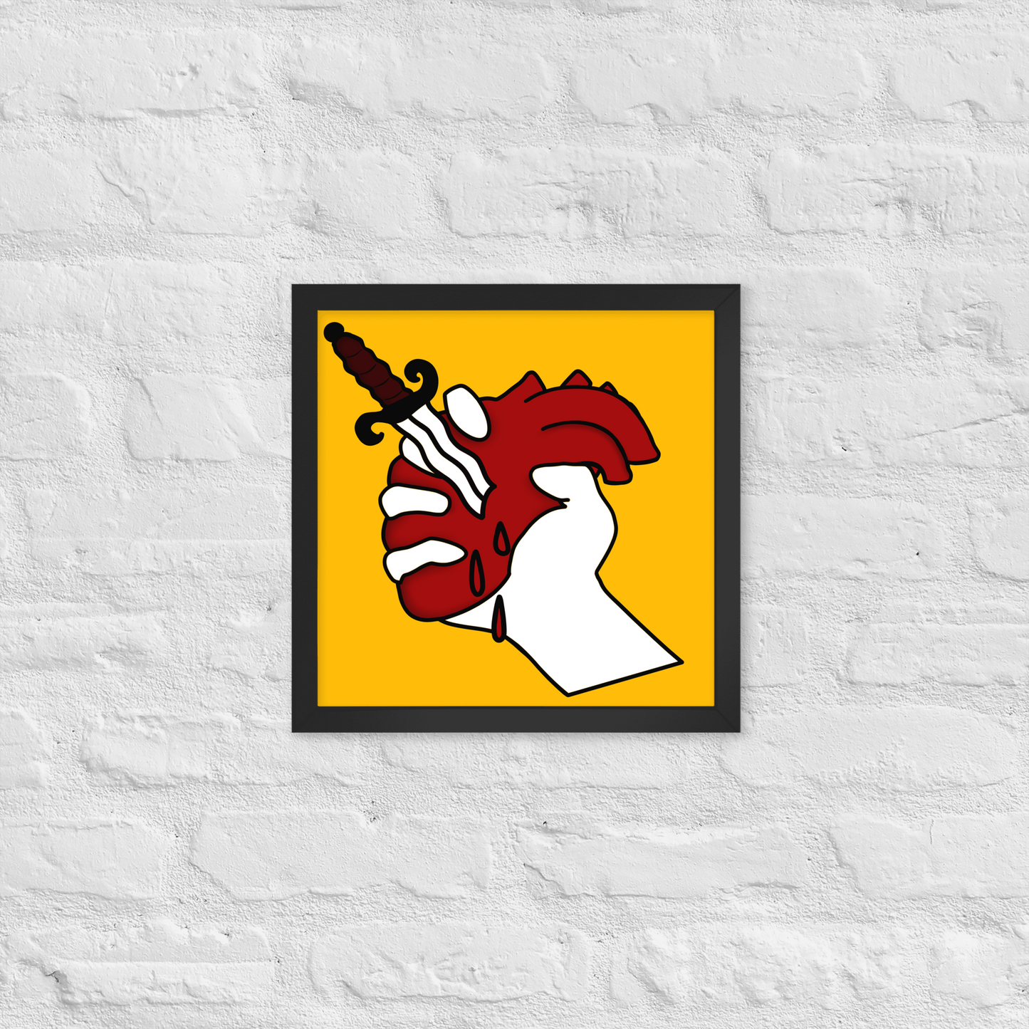 Framed artwork of a hand holding a dagger with a red heart on a yellow background, mounted on a textured white wall.