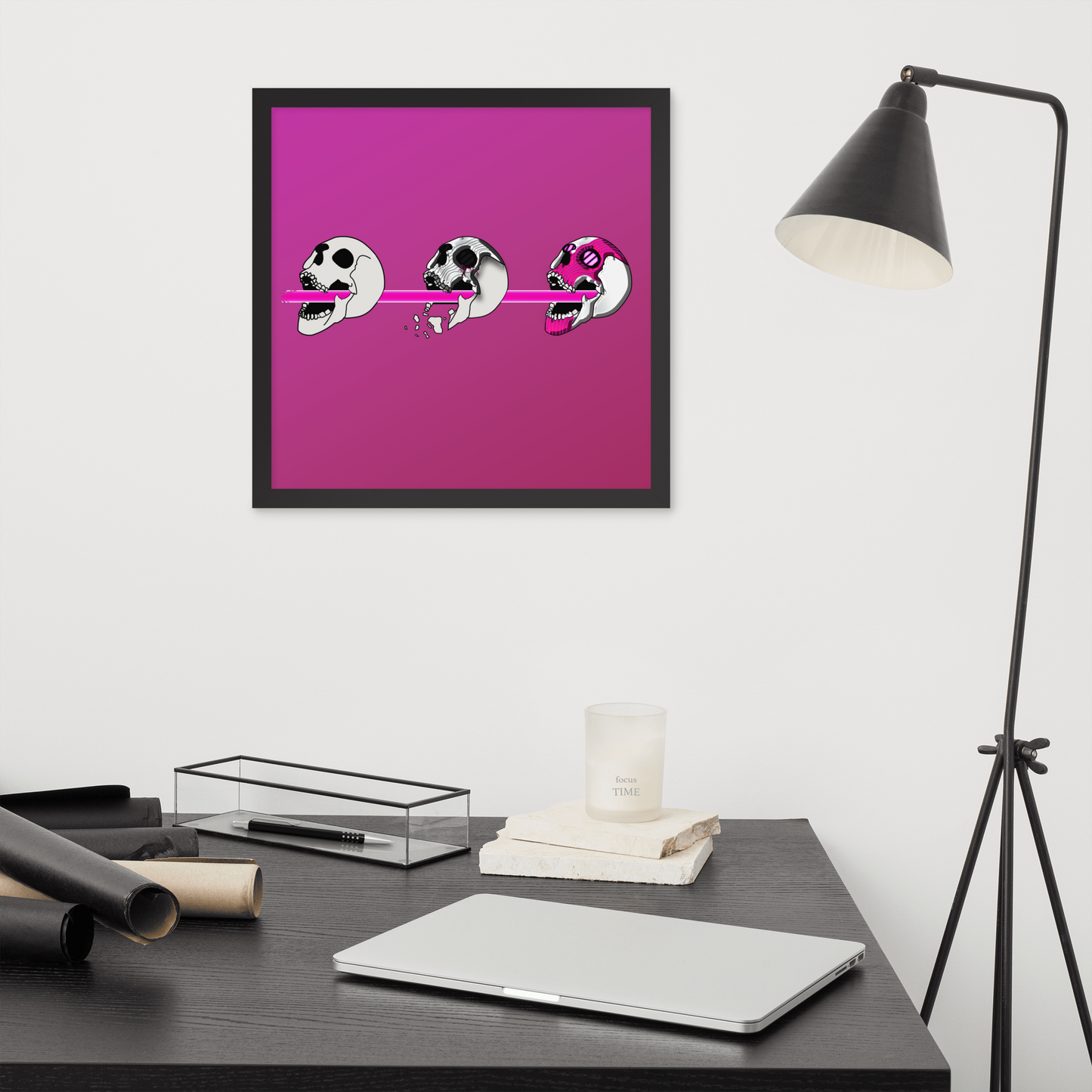Framed 16x16 artwork of a pink background and three stylized cyberpunk skull designs shooting a laser with purple and black details above a desk.