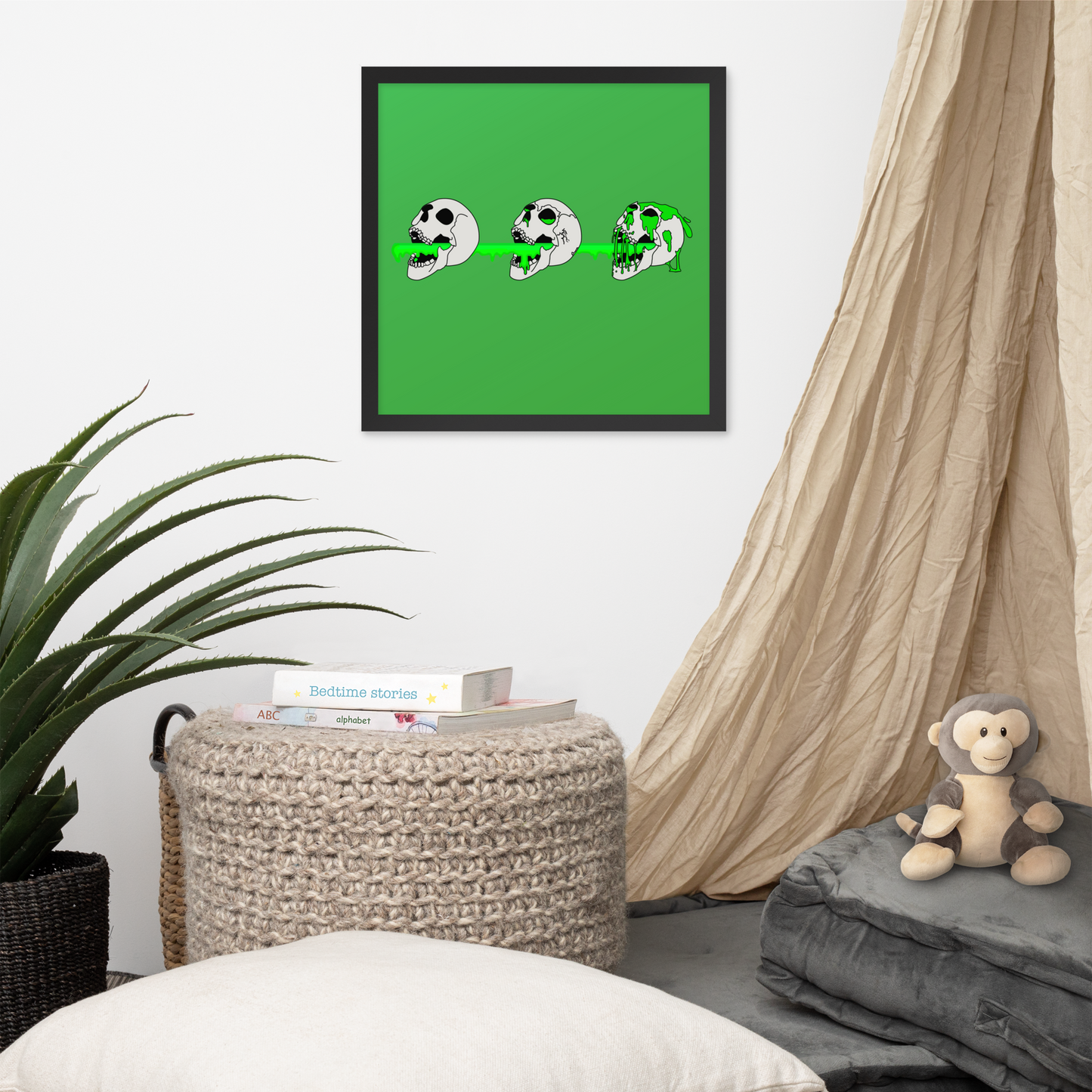 Framed artwork of 3 skulls shooting green slime from their mouths with a gradient background in a horror style, ottoman, and monkey plush toy.