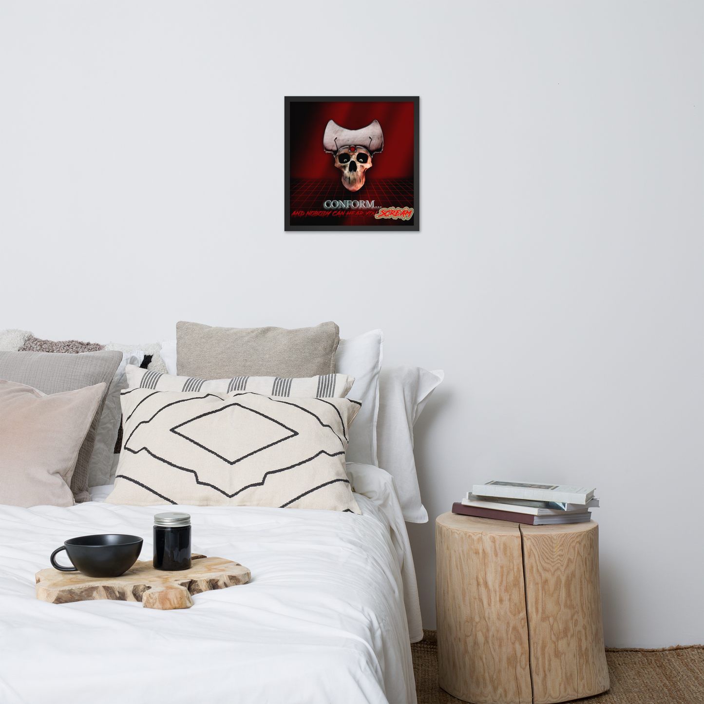 Bedroom with a bed, pillows, and a framed poster featuring a stylized skull wearing a white cap with a red and black background, and the text 'CONFORM.... AND NOBODY CAN HEAR YOU SCREAM' on the wall.