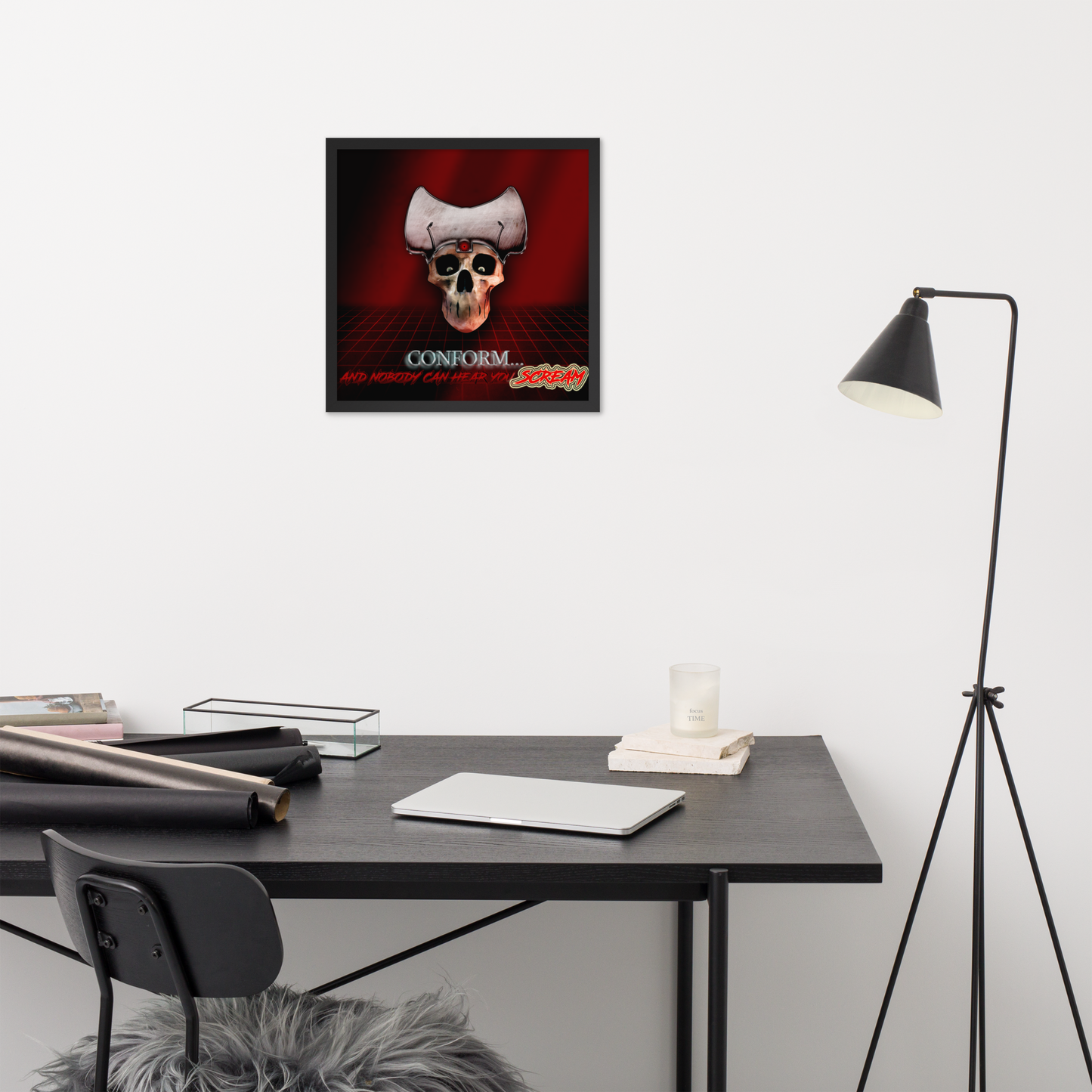 Framed poster with heavy metal skull design on a wall above a desk with office supplies.