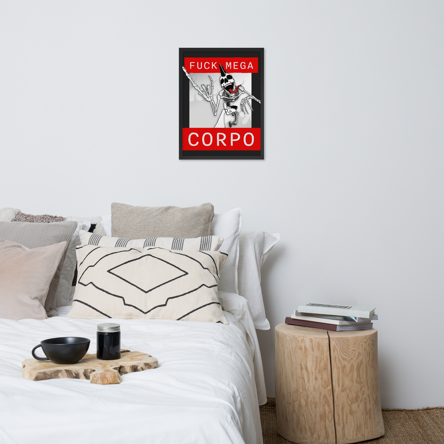 Bedroom with a bed, pillows, and a side table with a framed poster of a heavy metal skeleton in front of 'FUCK MEGA CORPO' text with red, white, black, and grey coloration the wall.