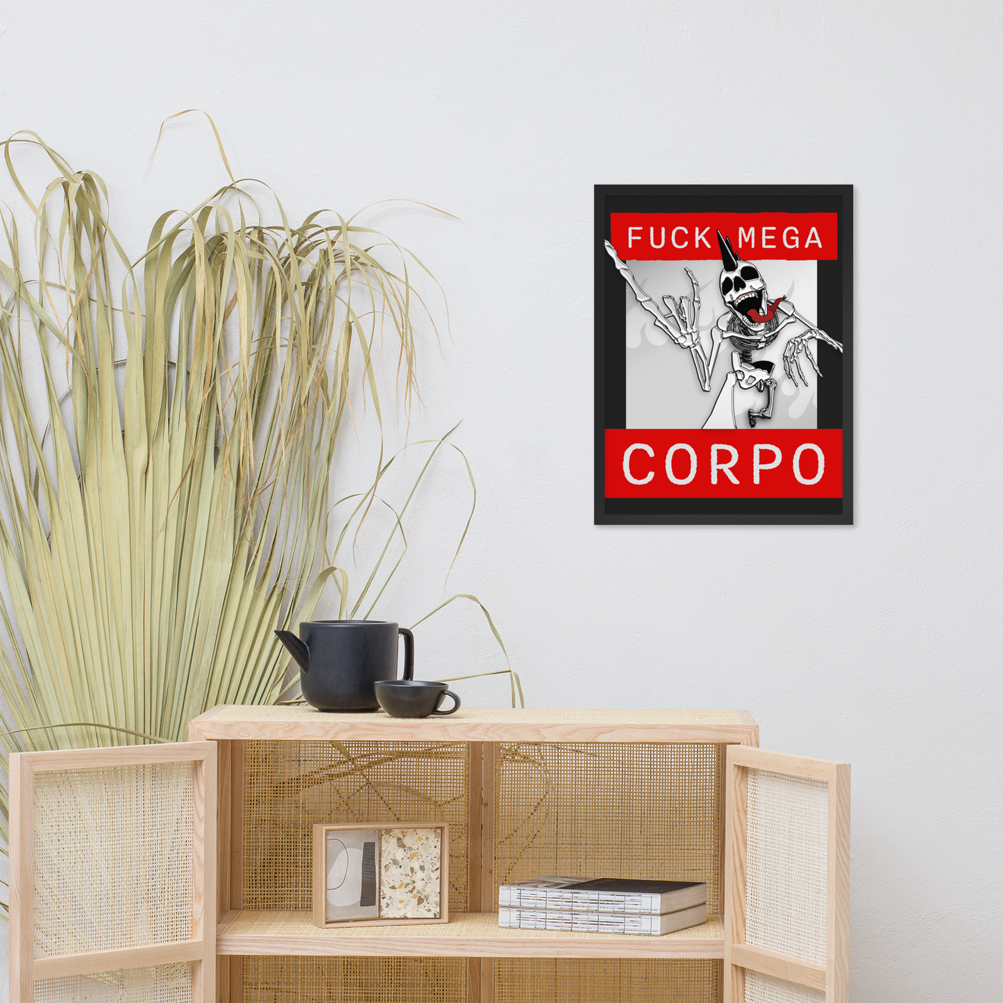 Framed artwork of a heavy metal skeleton in front of 'FUCK MEGA CORPO' text with red, white, black, and grey coloration on a wall above a wooden shelf.