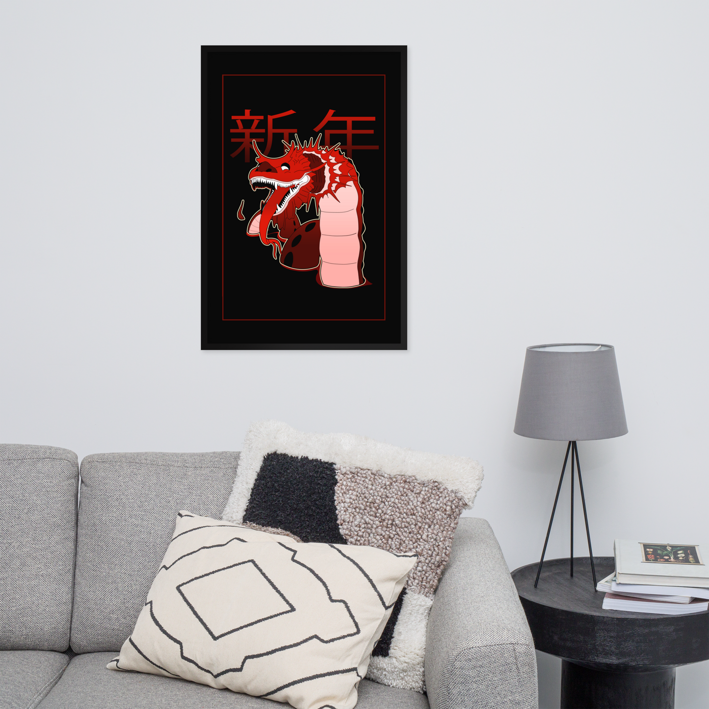 Framed artwork of a dragon with red accents on a wall above a gray sofa.
