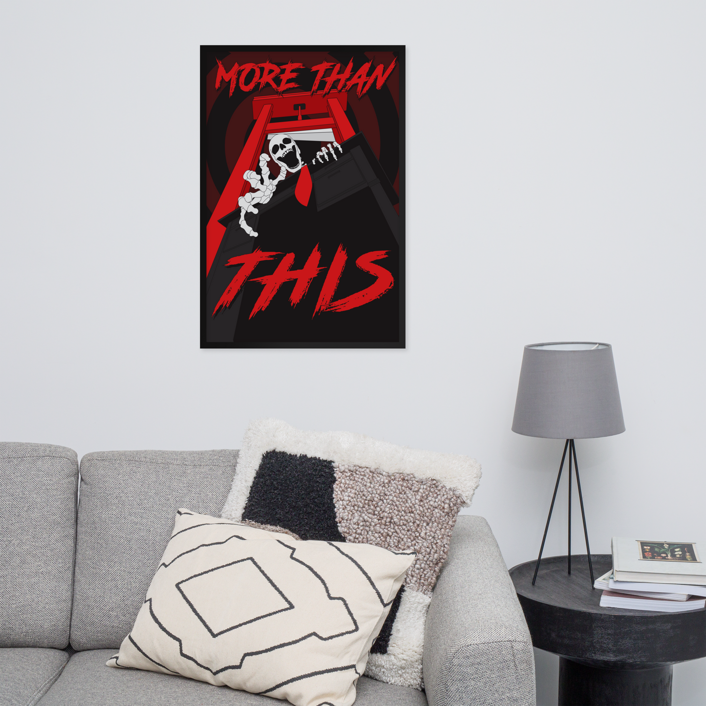 large poster with 'More Than This' design on a wall above a gray sofa.