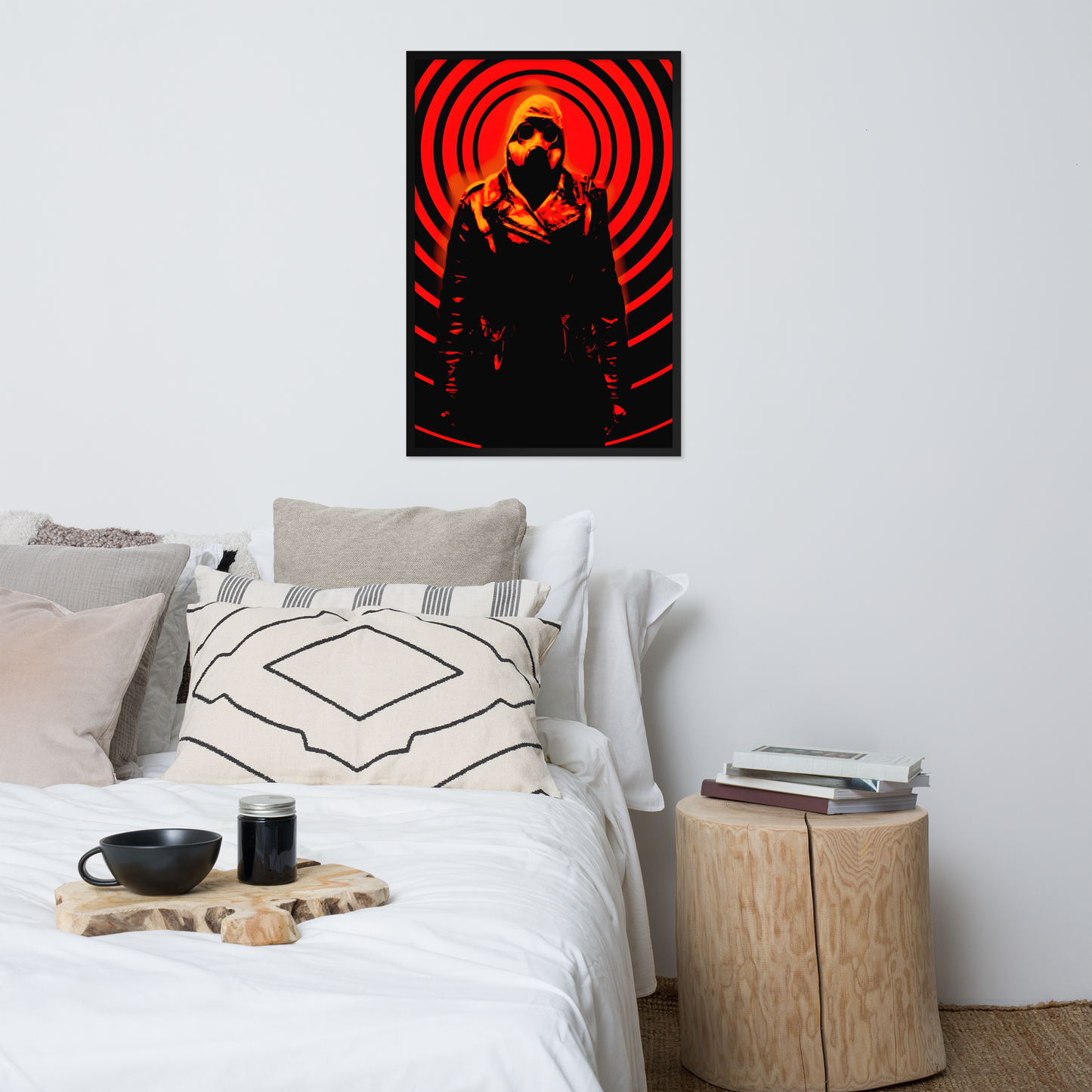 Framed poster of a mysterious figure in a dark outfit with a hood and a gas mask against an orange and black circular background above a bed in a bedroom.