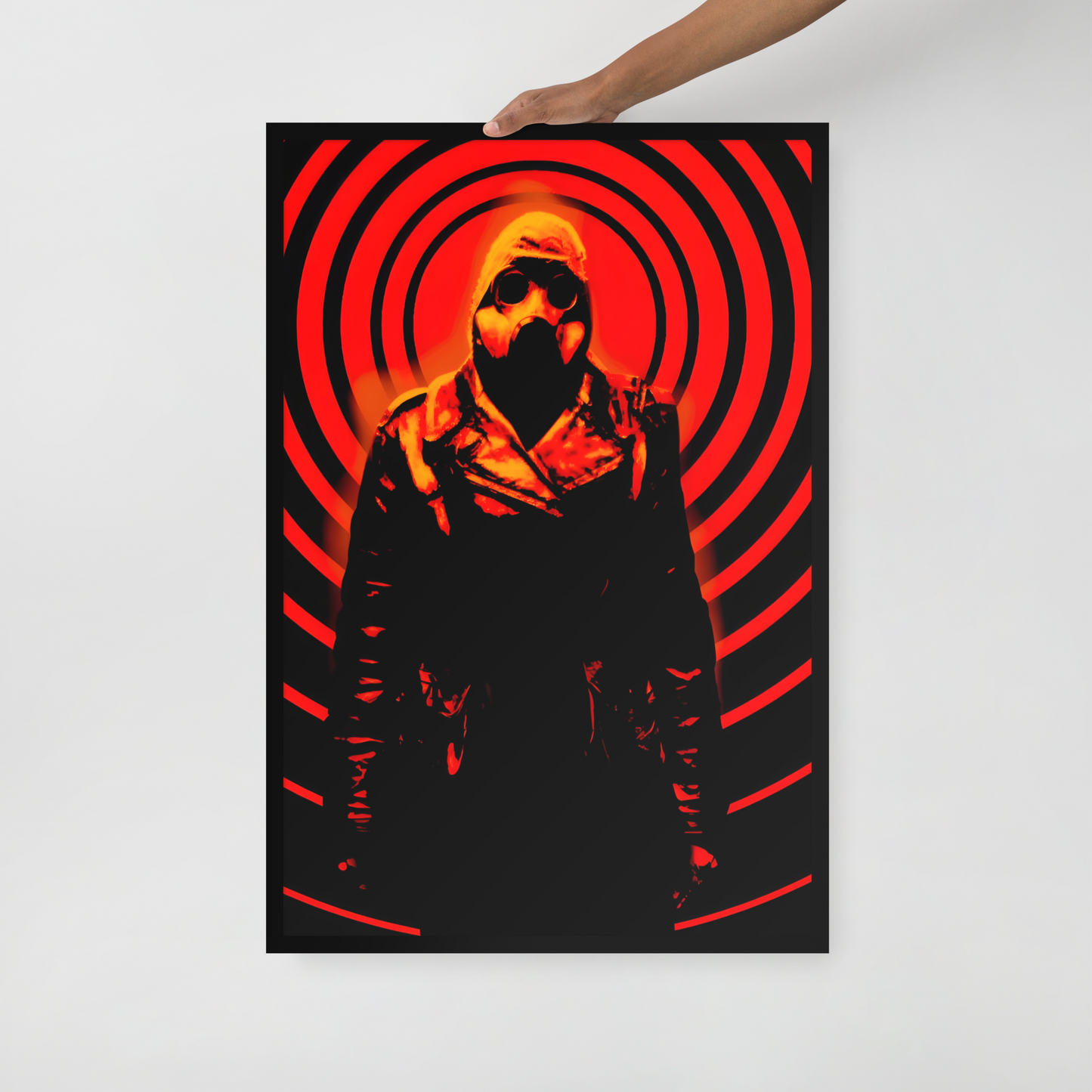 Person holding a 24x36 poster of a mysterious figure in a dark outfit with a hood and a gas mask against an orange and black circular background.