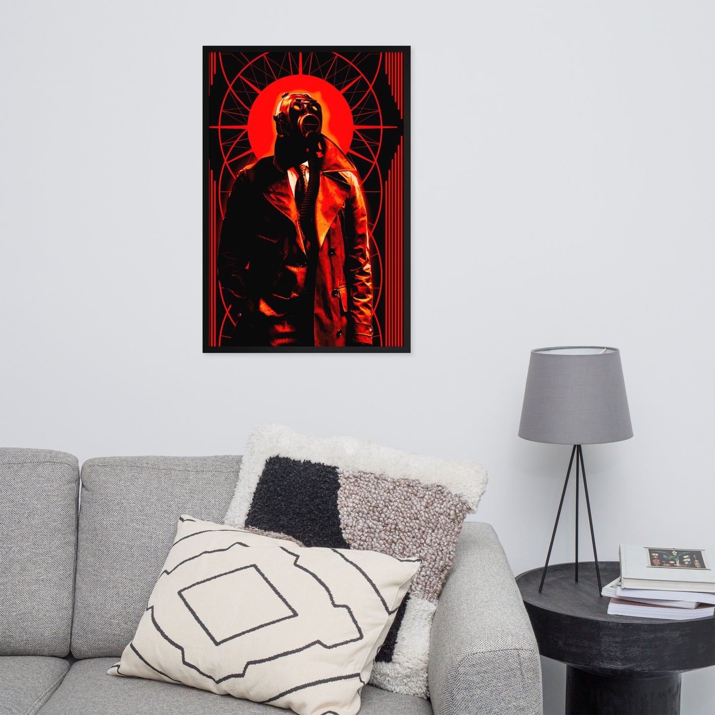 24x36 poster of a stylized, art-deco style illustration in orange, black, and white tones, with a mysterious figure in a gas mask and a trench coat in the center on a wall above a gray sofa with decorative pillows.