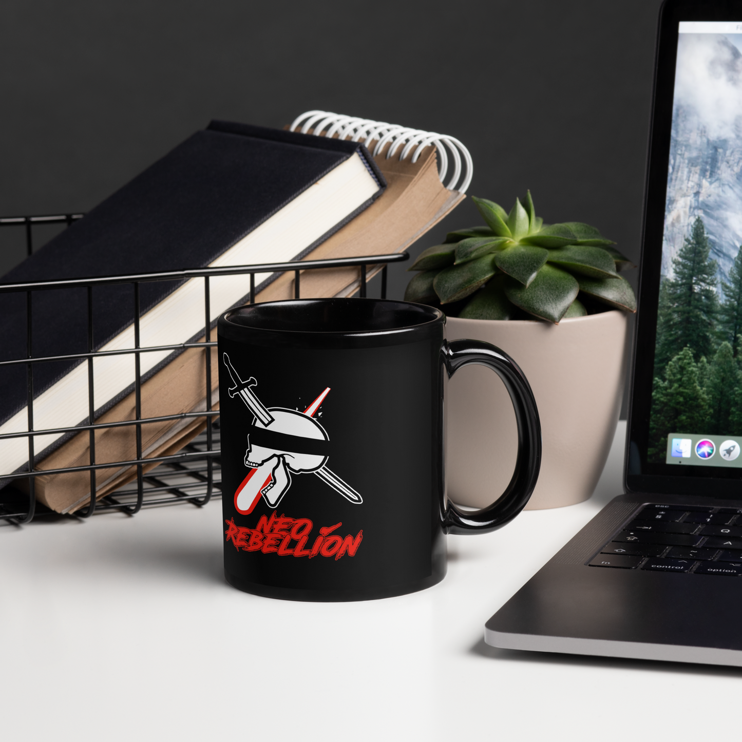 Black mug with 'NEOREBELLION' text on a desk with laptop, books, and plant