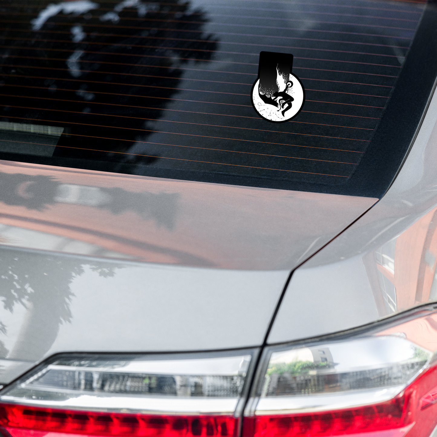 Car decal on a vehicle's rear window with a white circle design.