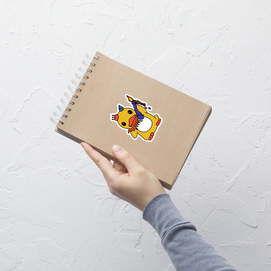 Notebook with a cartoon duck sticker held by a hand on a light gray background