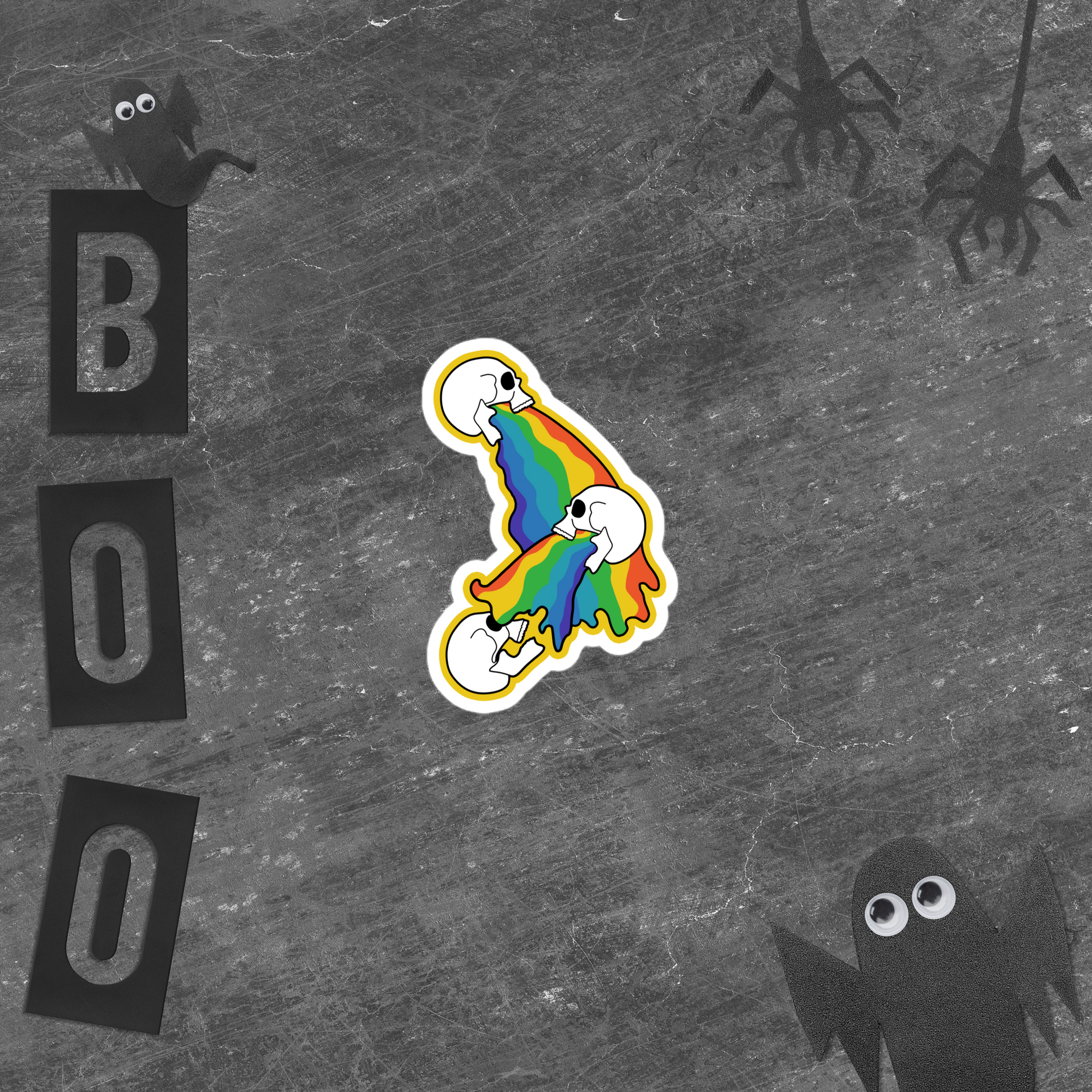 Colorful rainbow skull vomit sticker on a gray background with 'BOO' letters and black ghosts.