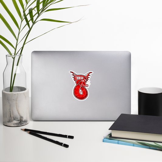 Laptop with a red snake sticker on a white surface with a plant, pencils, and books.