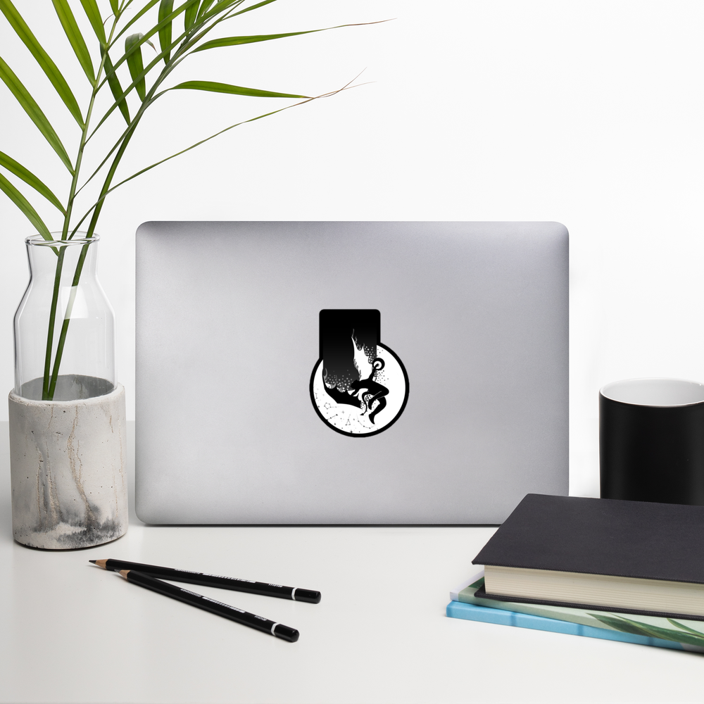 Laptop with a sticker on a desk with a plant, pencils, and books.