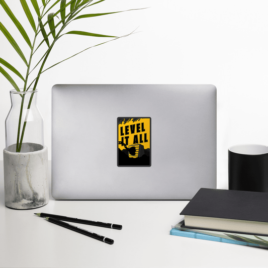 Laptop with a yellow and black sticker on a desk with a plant, pencils, and books.