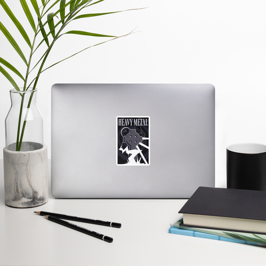 Laptop with a 'Heavy Metal' sticker on a desk with a plant, pencils, and books.