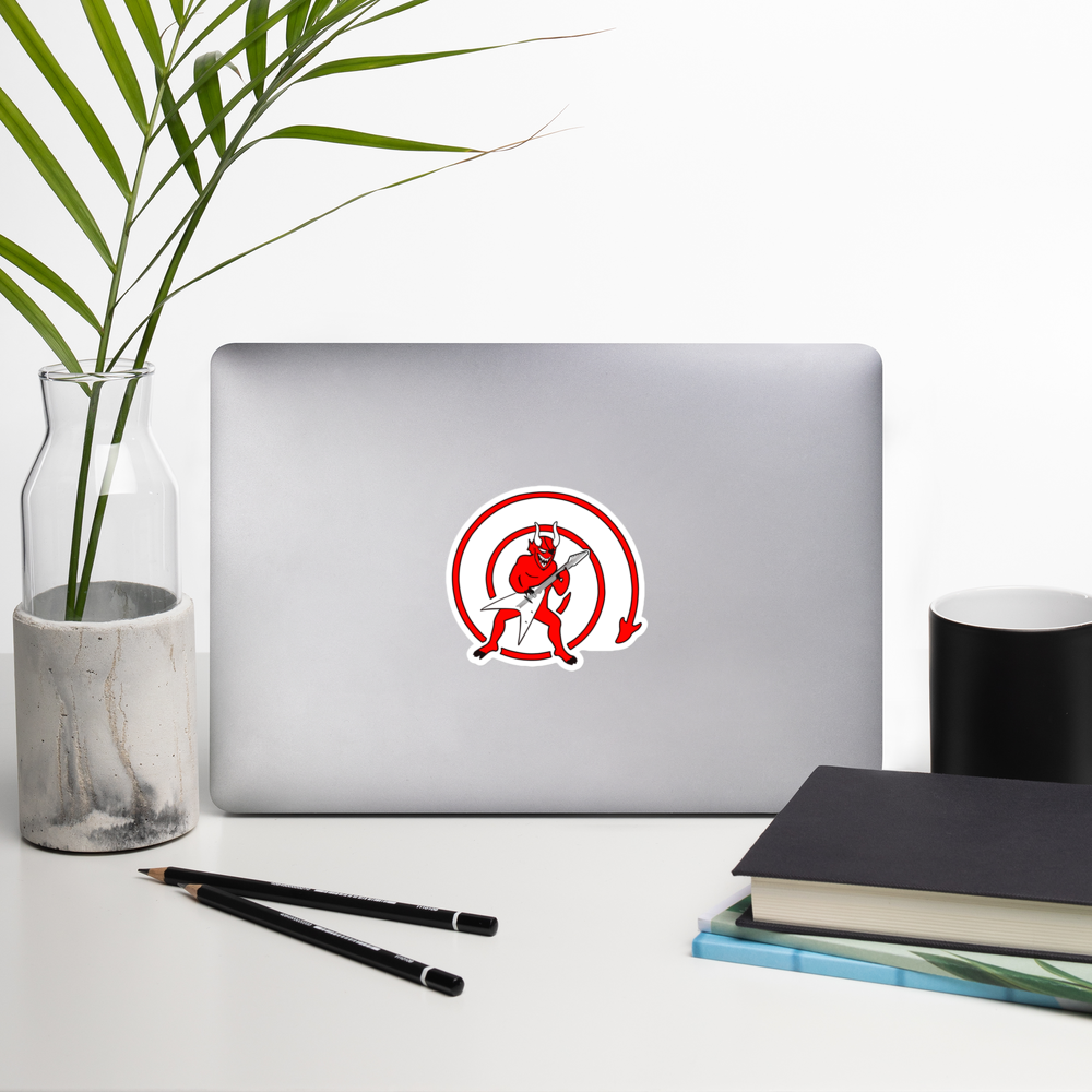 Laptop with a sticker of a red devil with a guitar inside a red circle on a white background on a desk with a plant, pencils, and books.