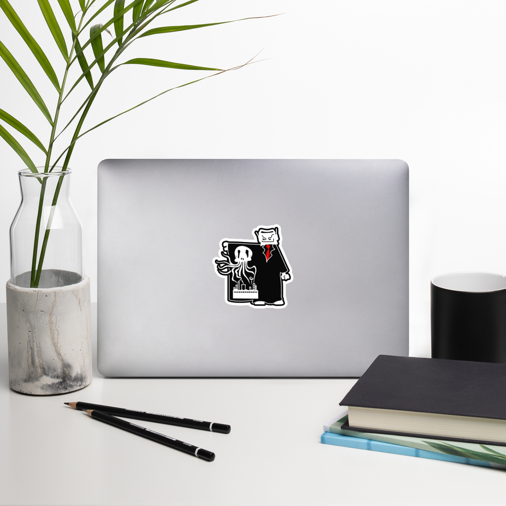 Laptop with a sticker on a desk with a plant, pencils, and books.