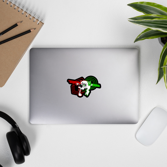 Laptop with a sticker on a desk with a notebook, pens, headphones, and a plant.