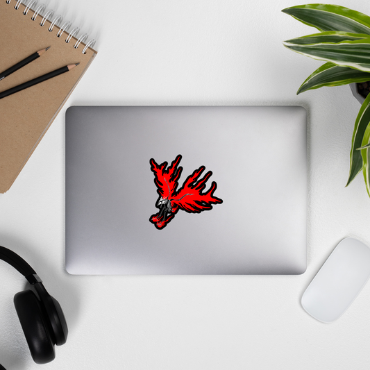 Laptop with a red and black design on a white surface with a notebook, pencils, and plant.
