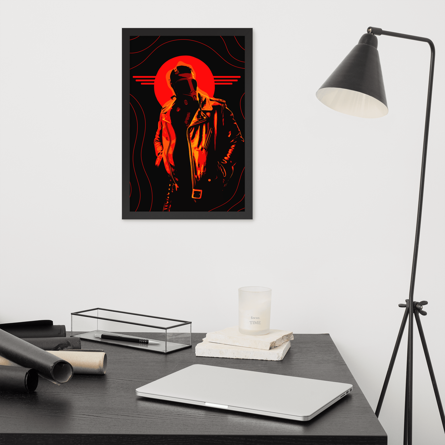 Framed artwork of a stylized figure with an orange circle on a wall above a desk.