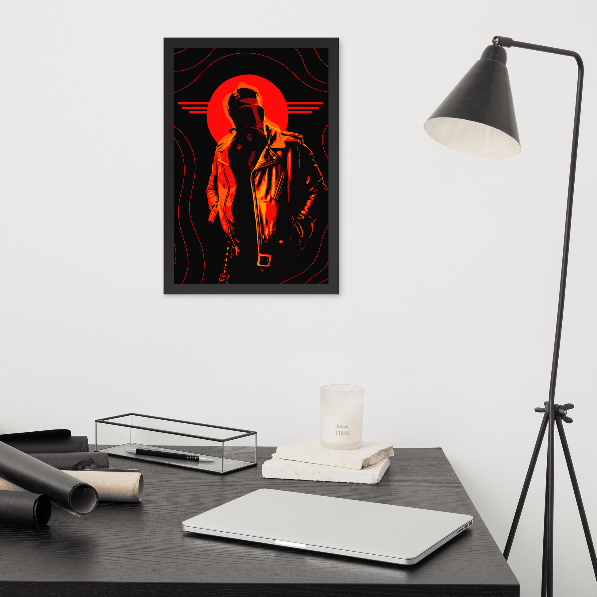 Framed artwork of a stylized figure with an orange circle on a wall above a desk.