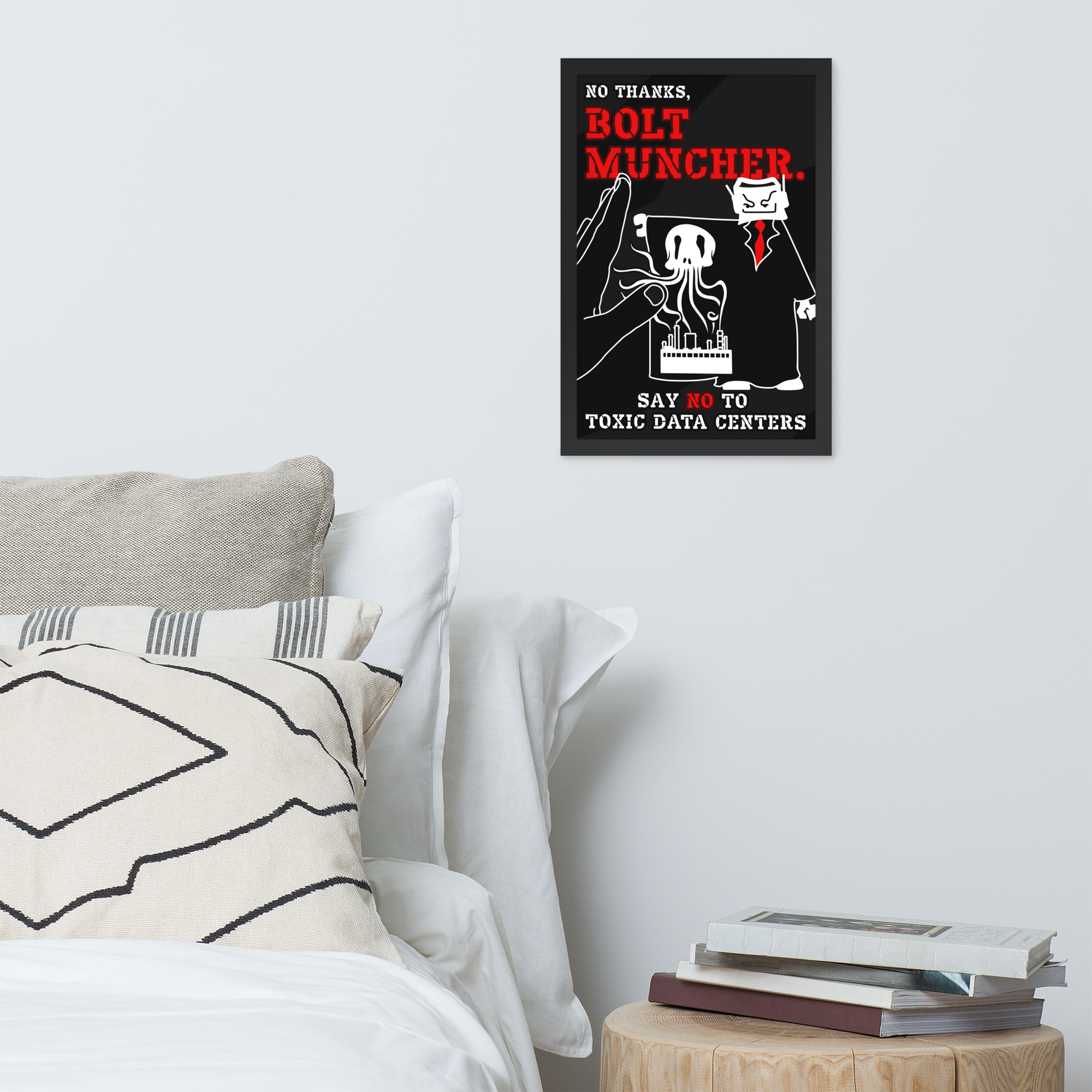 A framed black poster with a cartoon cat in a suit and bold red and white text reading 'NO THANKS, BOLT MUNCHER. SAY NO TO TOXIC DATA CENTERS,' displayed above a bed in a styled bedroom scene.