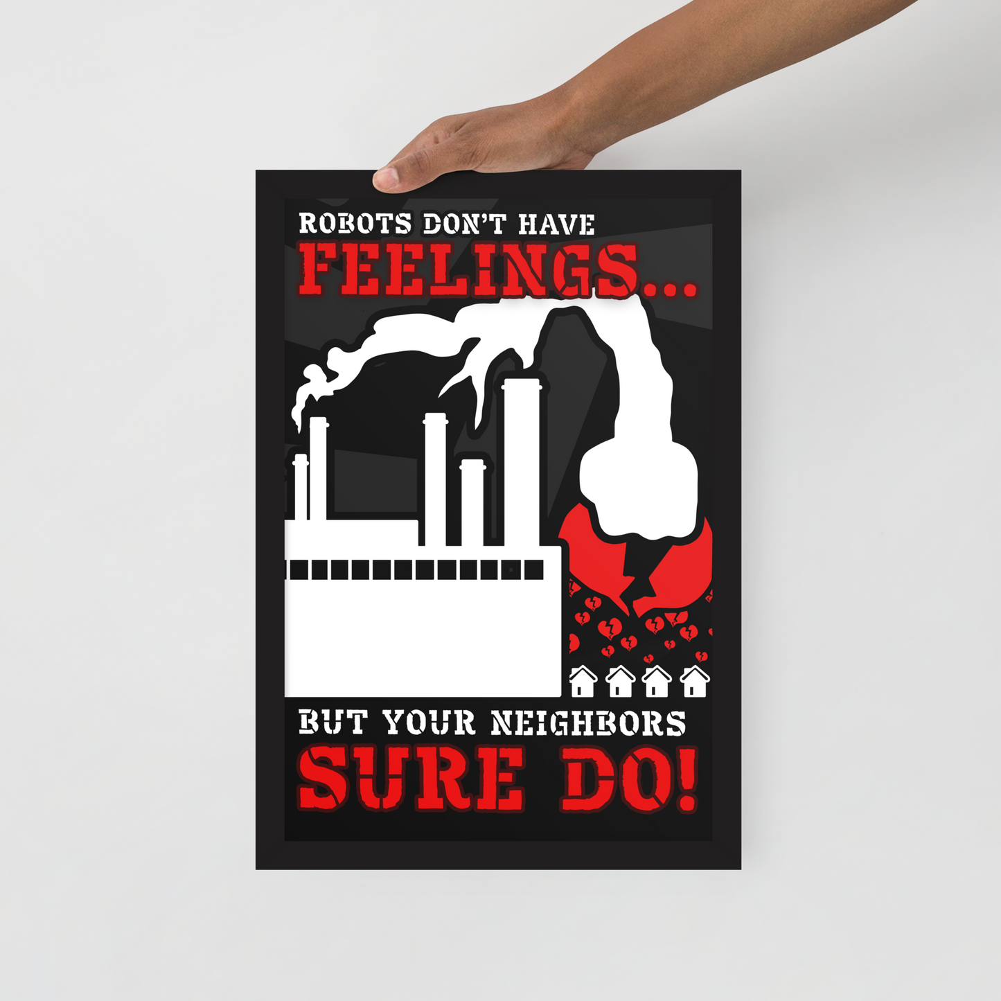 A hand holds a black poster with a bold red and white graphic and text reading 'Robots don't have feelings.