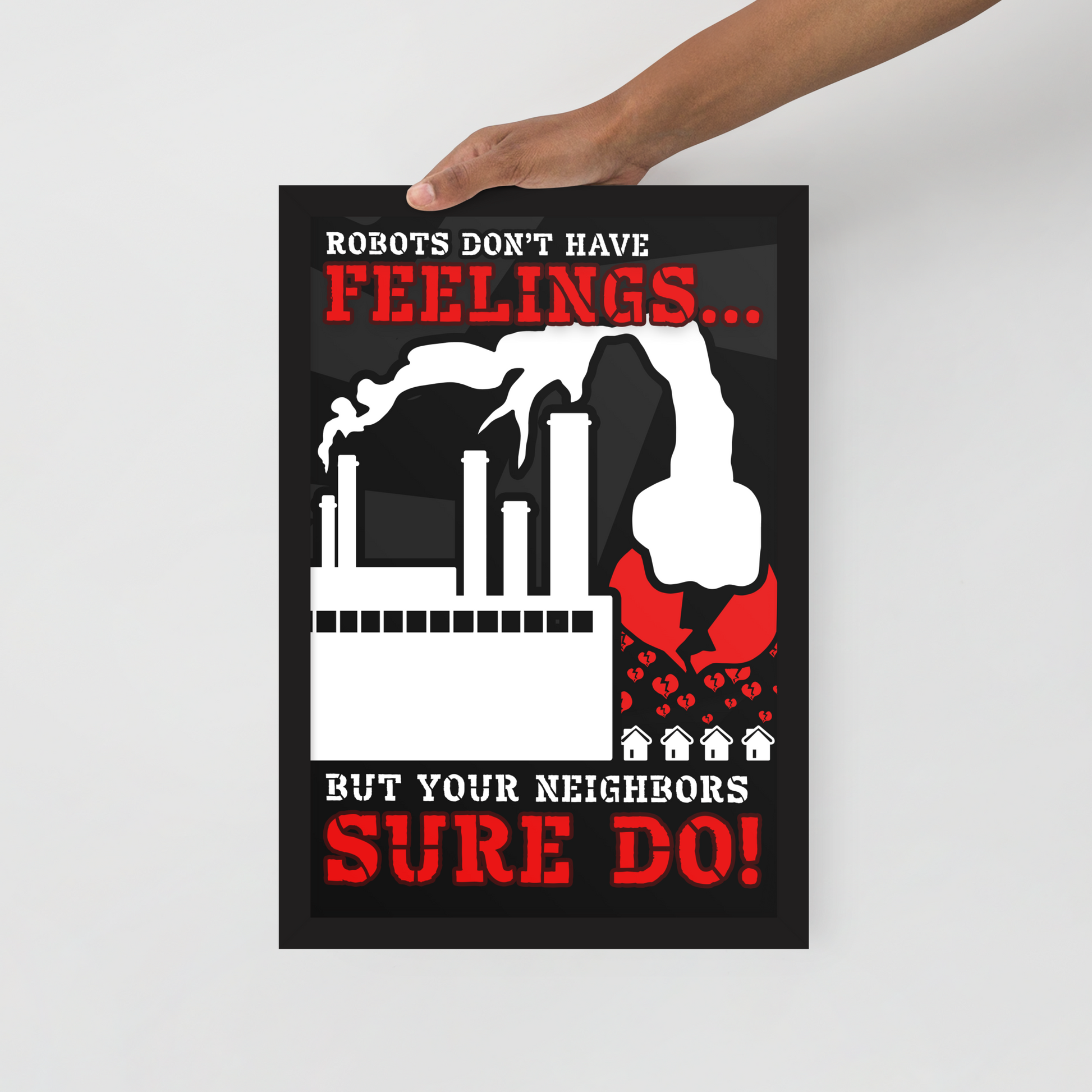 A hand holds a black poster with a bold red and white graphic and text reading 'Robots don't have feelings.
