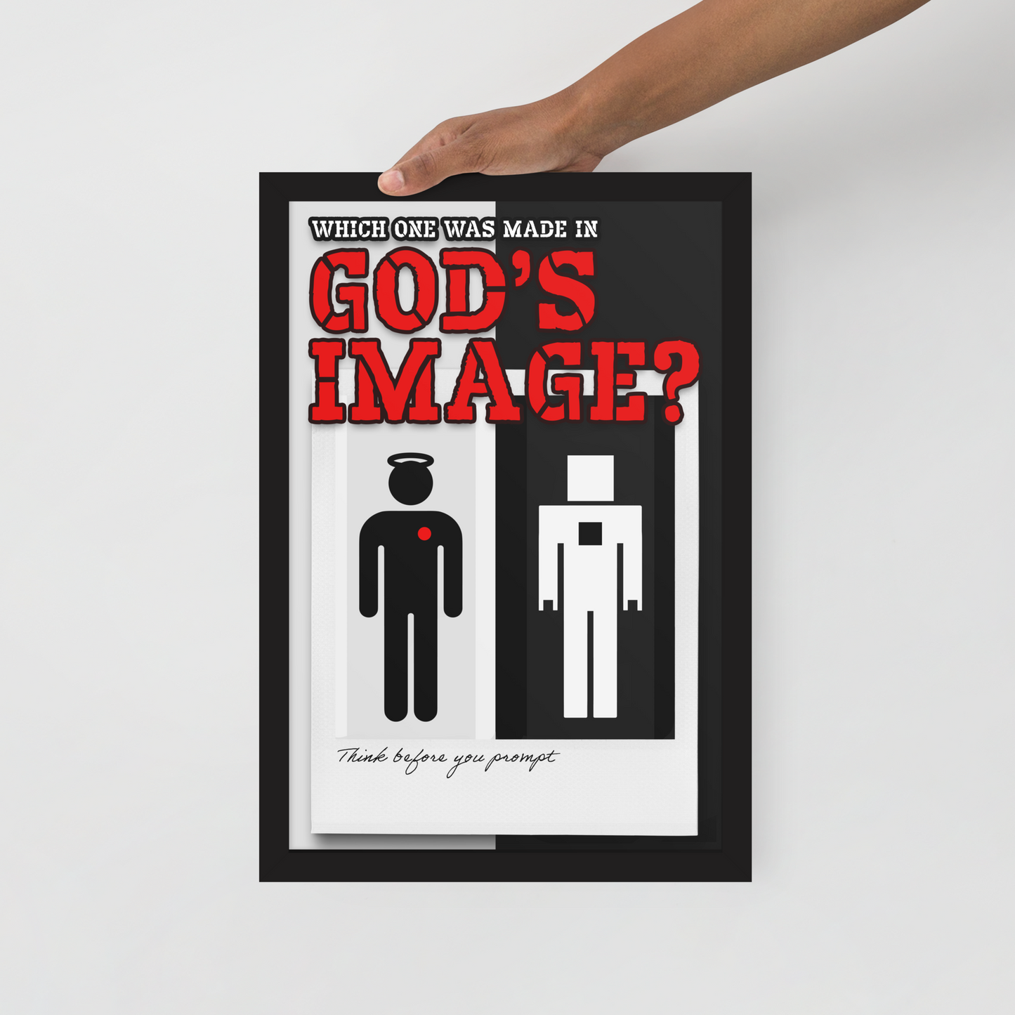 A framed minimalist art print with a black frame is held by a person's hand against a light gray background. The print features the text 'WHICH ONE WAS MADE IN GOD'S IMAGE?' in red and black, with two simple human figures below.