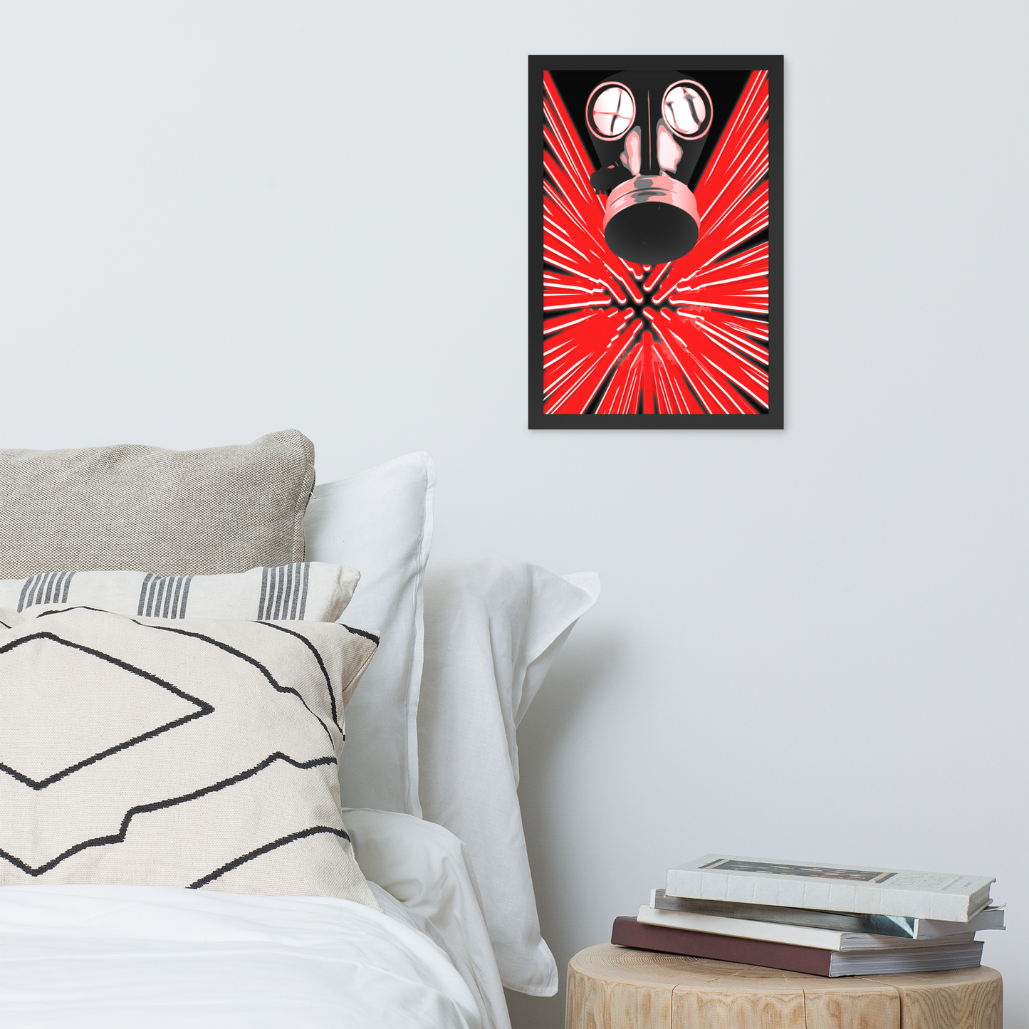 A framed wall art print featuring a stylized red and black gas mask with radiating red lines, displayed above a bed in a modern bedroom setting.