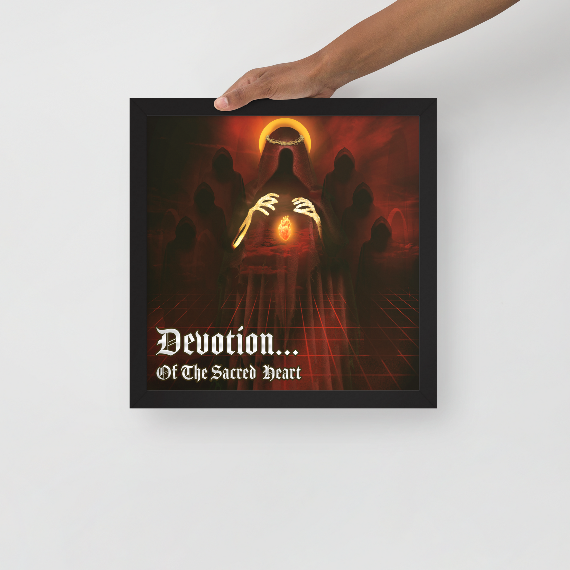 Framed artwork with a dark, mystical design and text 'Devotion... Of The Sacred Heart' held by a hand.
