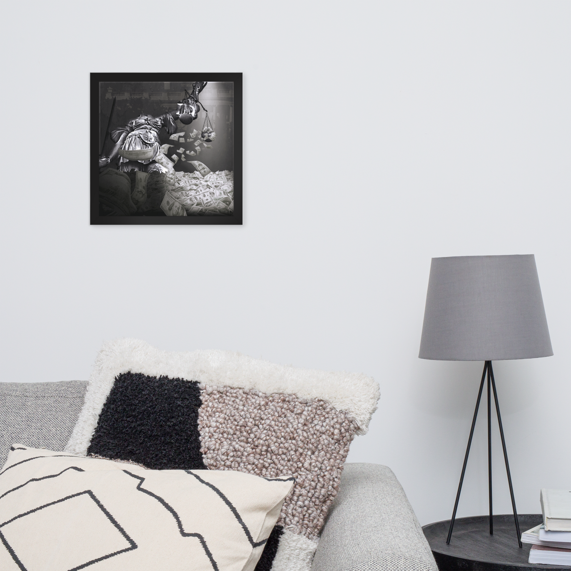 Framed black and white artwork above a sofa with decorative pillows and a lamp.