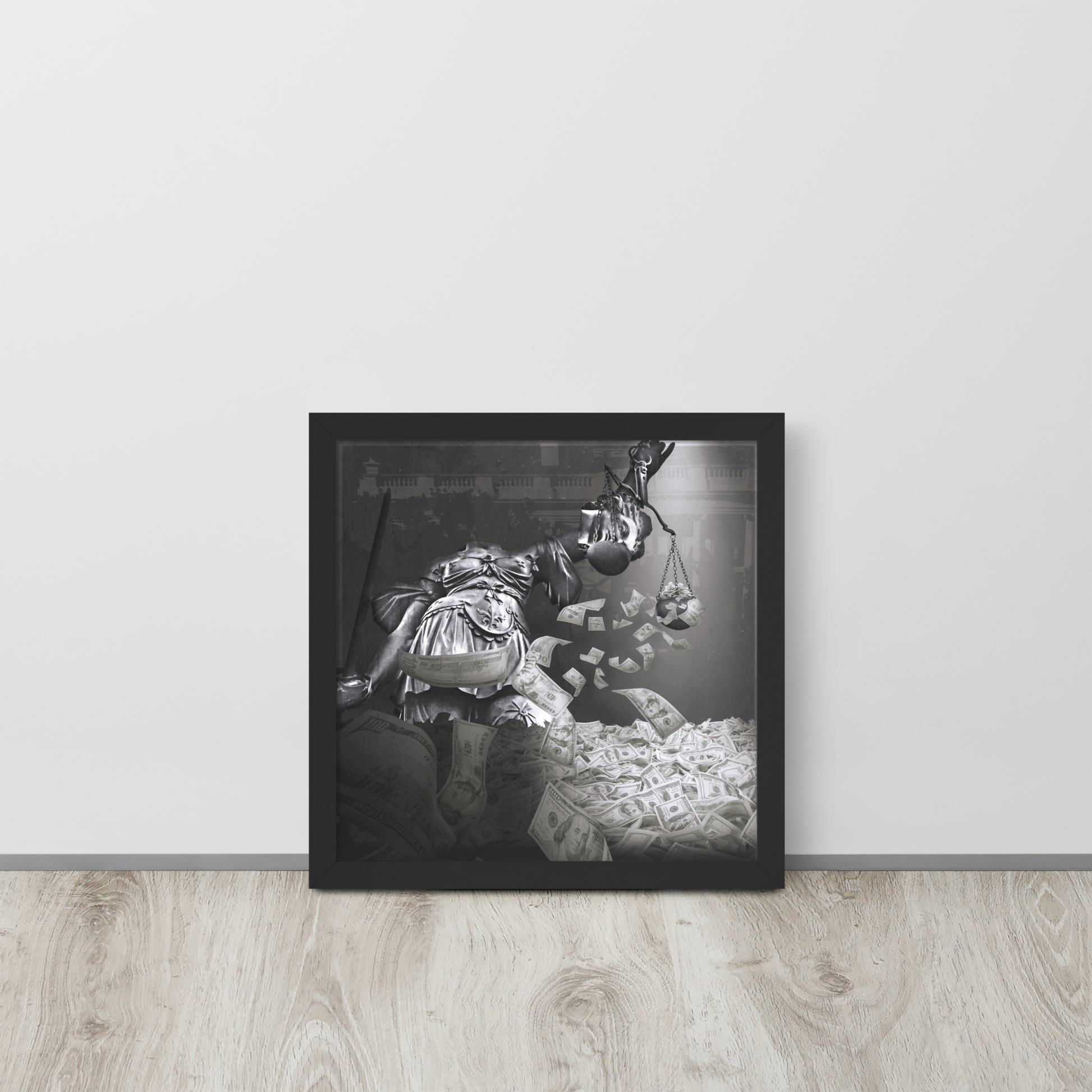 Framed black and white artwork of a person with a baby on a wooden floor against a light gray wall.